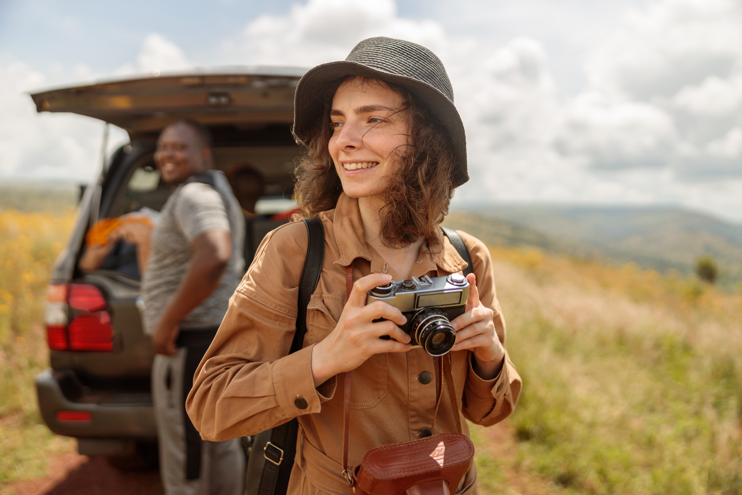 Happy female traveler enjoying the journey through the savannah - Tennis Destination
