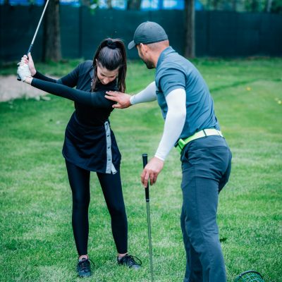 Individual golf lesson. Young woman having a golf lesson with golf instructor